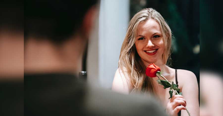 foreign woman holding a single red rose